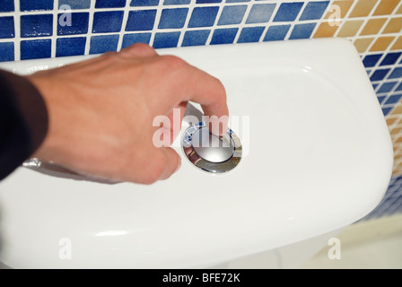 L'homme en utilisant la toilette à chasse d'eau double Banque D'Images