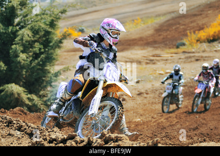 Le coureur de motocross féminin coin arrondi à d'autres coureurs à la poursuite Nanaimo Nanaimo friches de l'île de Vancouver en Colombie-Britannique Banque D'Images