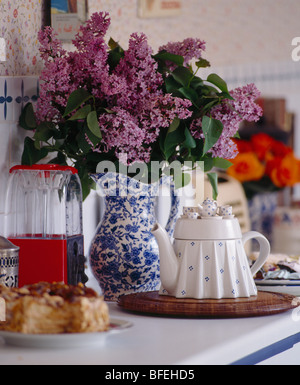 Close-up of purple lilac en bleu +blanc à côté de pot en forme de table théière sur petit plateau Banque D'Images
