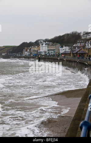 Sur une promenade Filey journée venteuse. Montrant les vagues qui aginast la mer de défense. Banque D'Images