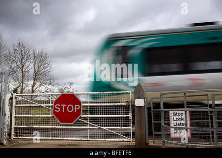 Passage du train au passage à niveau de gating habités, Worcestershire, Angleterre, Royaume-Uni Banque D'Images