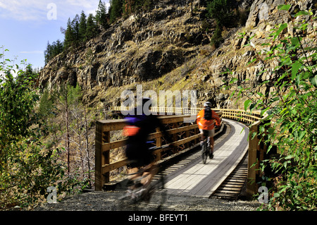 Deux cyclistes, brouillées, cross trestle à canyon Myra, ancien chemin de fer de Kettle Valley. Banque D'Images