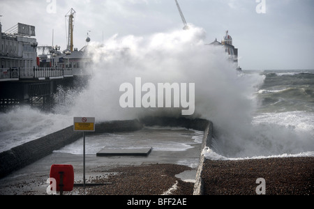 Les vagues déferlent sur un énorme épi par le Palace Pier Brighton lors d'une tempête sur le front UK Banque D'Images