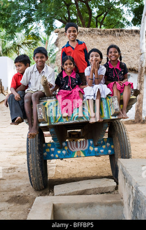 Six enfants Indiens assis sur une charrette dans un village de l'Inde rurale. L'Andhra Pradesh, Inde Banque D'Images