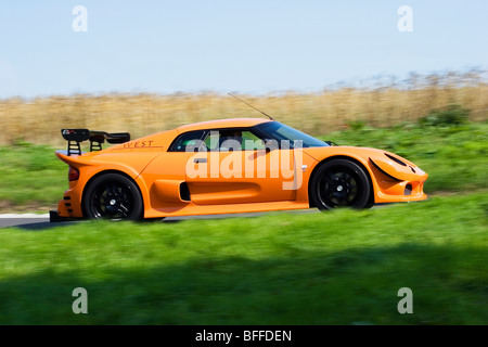 Profil (vue de côté) d'un bel orange fluorescent Noble M12 GT0-3R supercar britannique conduite rapide voiture de sport ou de course Banque D'Images