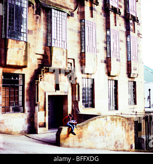 Une jeune fille lisant un livre à l'extérieur de la Glasgow School of Art building par Charles MacIntosh Renee Glasgow UK KATHY DEWITT Banque D'Images