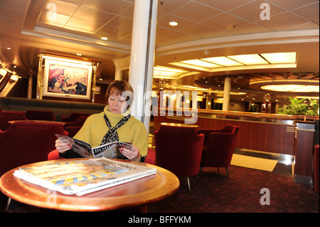 Passagère la lecture d'un magazine sur un ferry transmanche Seafrance Banque D'Images