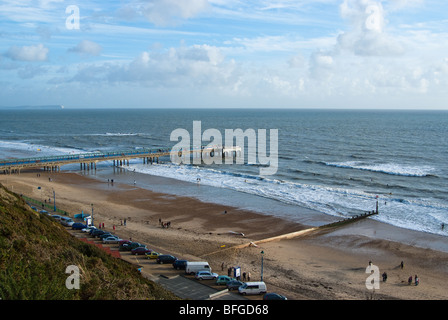 Surfeurs de Boscombe Pier. Le récif de surf artificielle peut être vu de l'autre côté de la jetée. Banque D'Images