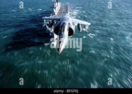 Royal Navy Sea Harrier avec HMS Invincible dans l'arrière-plan Banque D'Images