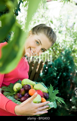 Jeune femme avec des fruits frais dans le jardin Banque D'Images