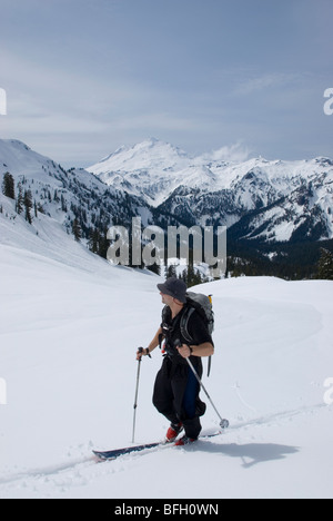 Skieur faisant son chemin en direction de Mt Ann sur une chaude journée de printemps avec Mt Baker à distance Mt Baker Wilderness National Pour Snoqualmie Banque D'Images