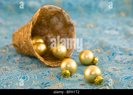 Boules d'arbre de Noël dans un décor bell disposés sur un fond de tissu coloré Banque D'Images