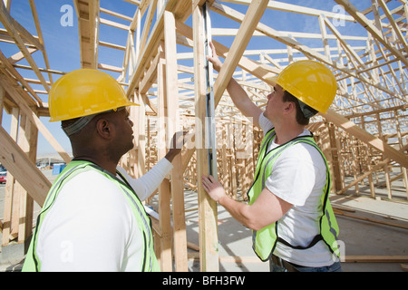 Deux travailleurs de la construction du cadre de mesure des capacités Banque D'Images