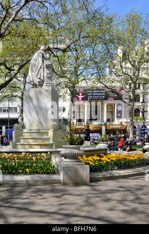 Journée du ciel bleu à Leicester Square, bulbes de printemps dans les jardins fleuris avec statue William Shakespeare et Casino Beyond au cinéma Empire Londres Angleterre Royaume-Uni Banque D'Images