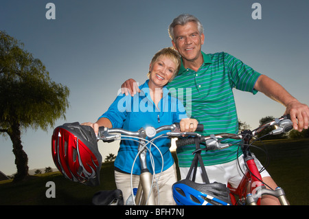 Couple sur les bicyclettes au crépuscule, portrait Banque D'Images