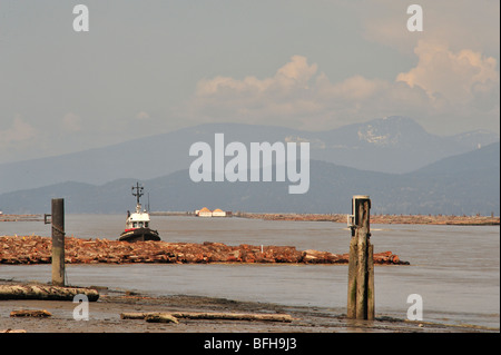 Bateau remorqueur amarré à log flèche sur bras nord du fleuve Fraser. Iona Beach avec vue sur la plage de la côte, Richmond, British Columbia Canada Banque D'Images