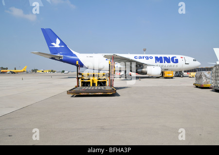 L'aéroport international Ben Gourion, Israël véhicule d'entretien sur le tarmac. Un avion cargo MNG en arrière-plan Banque D'Images