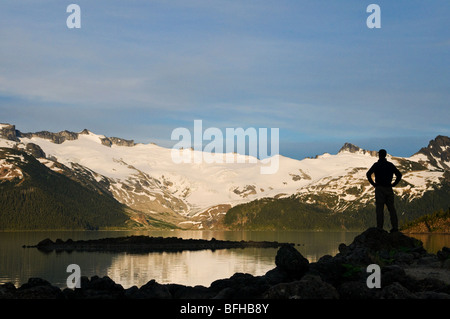 A hiker is silhouetted by the Sphinx Glacier at Garibaldi Lake in Garibaldi Provincial Park near Whistler BC. Banque D'Images