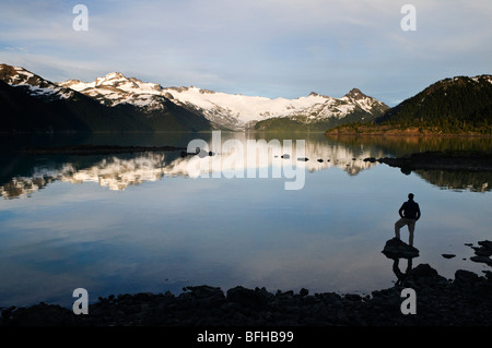 A hiker is silhouetted by the Sphinx Glacier and Garibaldi Lake in Garibaldi Provincial Park near Whistler BC. Banque D'Images