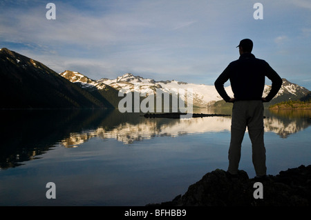 A hiker is silhouetted by the Sphinx Glacier at Garibaldi Lake in Garibaldi Provincial Park near Whistler BC. Banque D'Images
