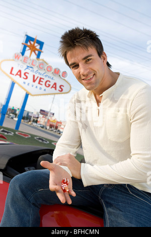 Man holding dice, Las Vegas sign 'bienvenue' en arrière-plan Banque D'Images