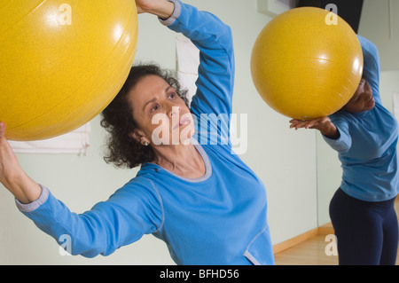 Senior Woman Using Exercise Ball in Fitness Class Banque D'Images