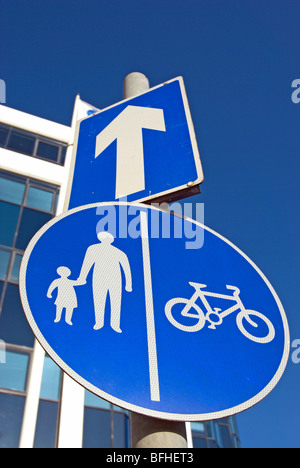 La signalisation routière indiquant une rue à sens unique, d'une flèche blanche, et des couloirs séparés pour les cyclistes et piétons Banque D'Images