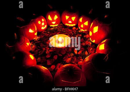 Les citrouilles sculptées dans un cercle au crépuscule autour d'une tarte à la citrouille le soir de l'Halloween Banque D'Images