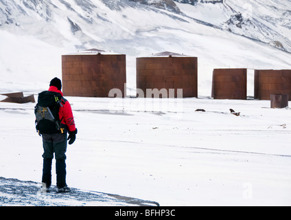 Un touriste sur l'Île Déception dans l'Antarctique à la rouille à l'réservoirs qui une fois enregistré l'ancienne base de la chasse à la baleine est l'huile de baleine Banque D'Images