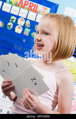 Élève d'école élémentaire avec les cartes Flash Alphabet Banque D'Images