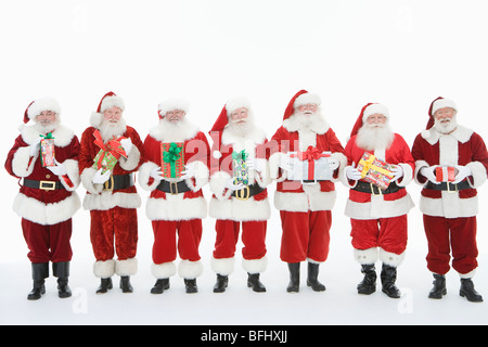 Groupe d'hommes habillés en Père Noël holding gifts Banque D'Images