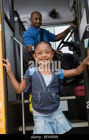 Petite fille de descendre des Schoolbus Banque D'Images