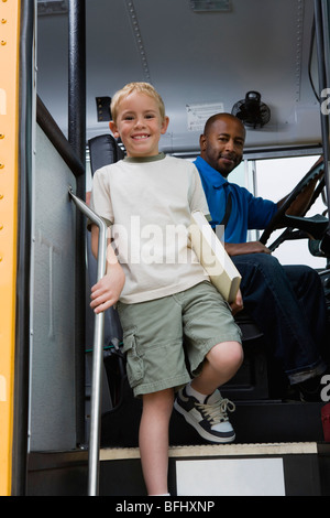 Petit garçon descendre de Schoolbus Banque D'Images