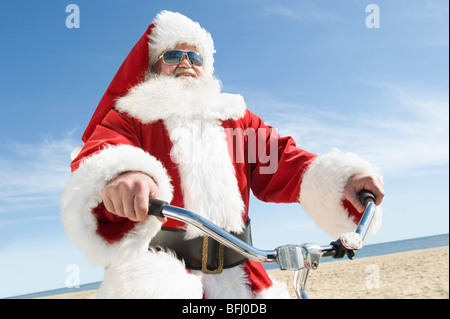 Le Père Noël avant de plage le long de cycles Banque D'Images