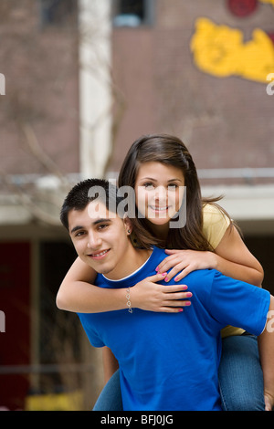 Teenage Boy Giving Girlfriend Piggy Back Ride Banque D'Images