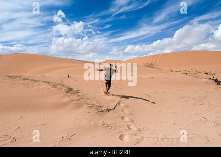 Monde Naturel du désert de Jordanie- un jeune homme aime la sensation de couler sur une dune de sable en Jordanie Banque D'Images