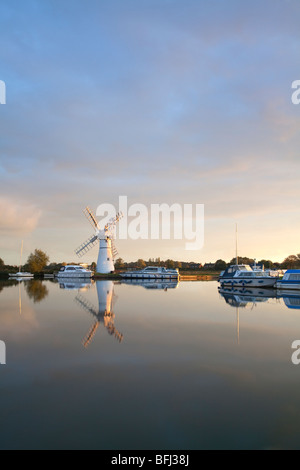 La rivière Thurne à l'aube avec drainage Thurne mill reflétant dans l'eau tranquille calme. Banque D'Images