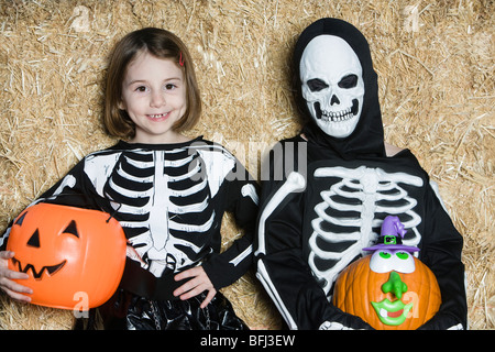 Portrait of girls (7-9) wearing skeleton costumes, avec jack-o-lanternes Banque D'Images