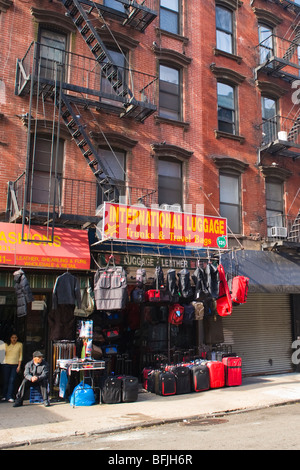 New York City , la Grande Pomme typique , Lower East Side , brique rouge tènements avec metal fire escapes & assurance magasin ou boutique Banque D'Images
