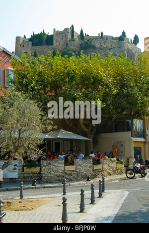 Voir des gens dans un bar-café dans le sud de la France Cassis avec château perché dans l'arrière-plan Banque D'Images