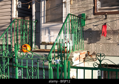 Fermer voir marches modeste maison ancienne dans Red Hook Brooklyn avec vert lumineux en fer forgé & Halloween citrouille sculptée Banque D'Images