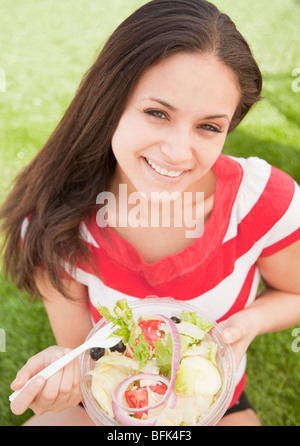 Mixed Race woman eating salad Banque D'Images