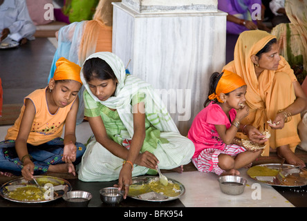 Les femmes indiennes de manger un Thali (traditionnel repas indien). Le temple d'or libre communauté à manger. Amritsar. Punjab. L'Inde Banque D'Images