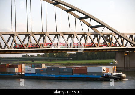 Barge à conteneurs commerciaux 'Joline' la voile sur le Rhin sous le marteau Eisenbahnbrucker bridge, Düsseldorf, Allemagne. Banque D'Images