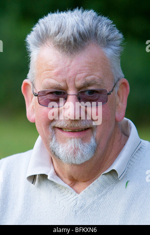 Âge moyen à l'extérieur de l'homme blanc à la recherche de l'appareil photo et souriant Banque D'Images