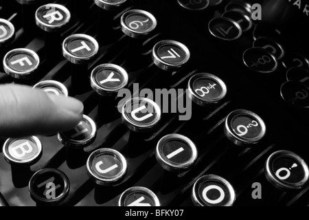 A woman's hand saisie sur une ancienne machine à écrire des années 30. Banque D'Images