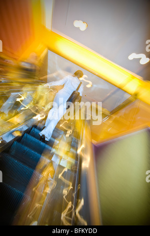 Femme sur Escalator In Shopping Mall, New York, USA Banque D'Images