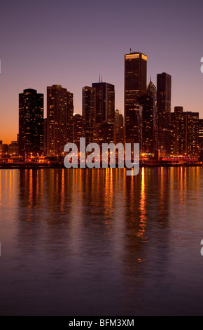 La ville de Chicago compte dans le lac Michigan au crépuscule après le coucher du soleil avec un ciel rose pourpre du Navy Pier Banque D'Images