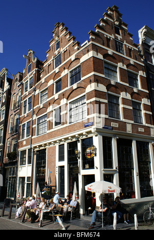 Des gens profitant d'un café en plein air dans un bâtiment d'angle historique au bord du Prinsengracht à Amsterdam, Pays-Bas. Banque D'Images