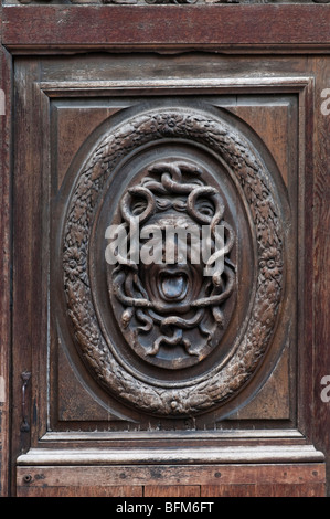 Détail d'un effrayant visage sculpté dans un grand et vieux bois porte dans le quartier du Marais, Paris Banque D'Images